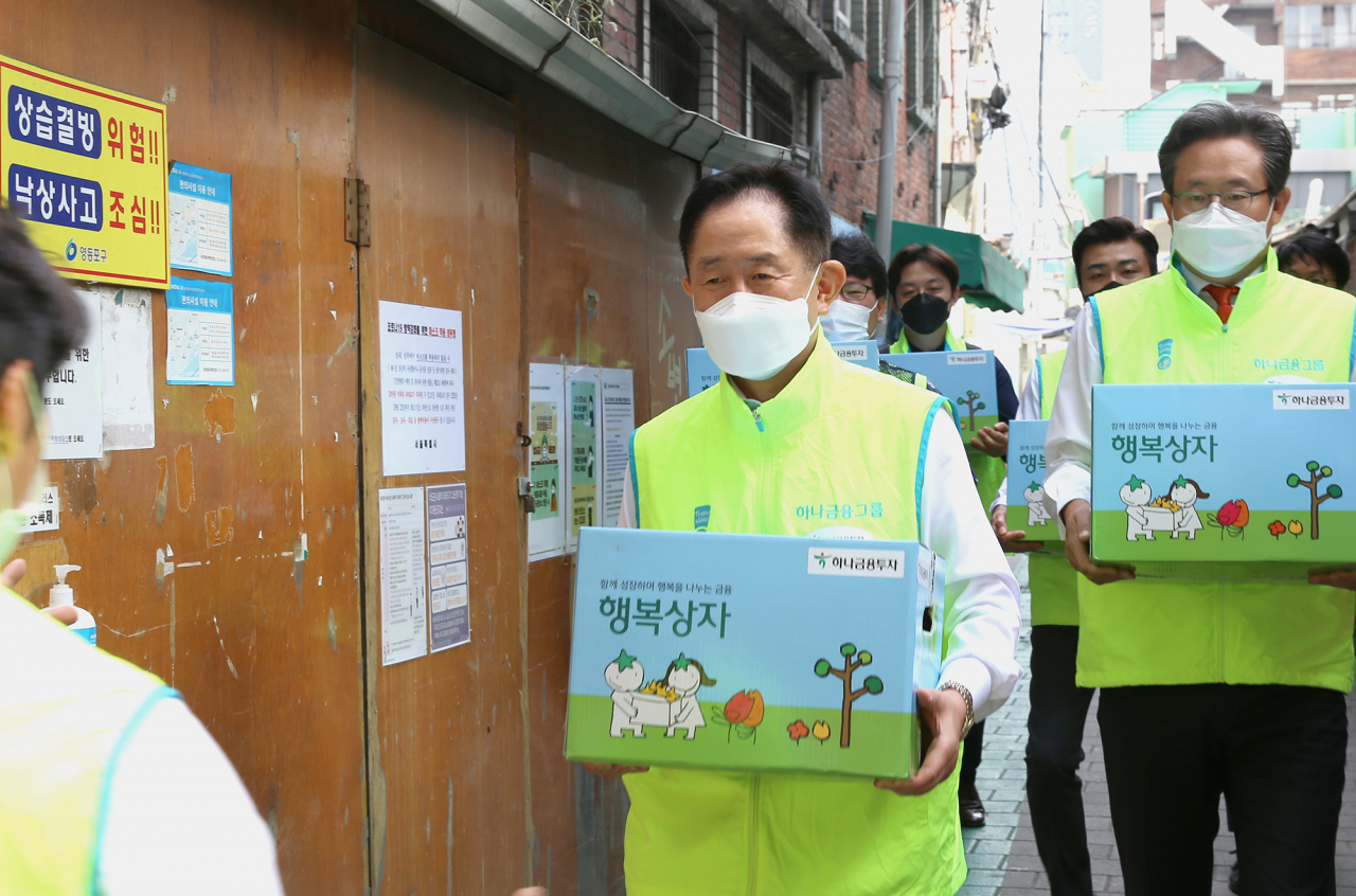 이진국 하나금융투자 사장(맨앞)과 하나금융투자 임직원들이 29일 '행복상자'를 갖고 영등포 쪽방촌을 방문했다. [사진=하나금융투자]
