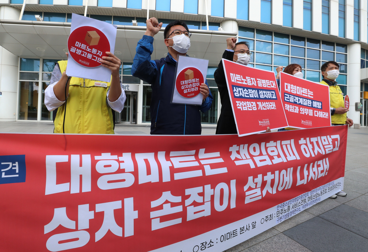 지난달 28일 오후 서울 성동구 이마트 성수점 앞에서 마트산업노동조합 관계자들이 기자회견을 열고 마트 노동자들의 근골격계 질환 예방을 위해 상자 손잡이 설치와 작업환경 개선을 대형마트 업계에 촉구하고 있다. [연합]