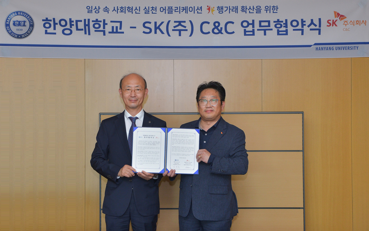 한양대학교에서 안석호 SK(주) C&C 행복추진센터장(오른쪽)과 김명직 한양대 교학부총장이 '행가래를 통한 생활 속 사회적 가치 확산 협력 협약' 체결 후 기념 촬영하는 모습. [ SK(주) C&C 제공]