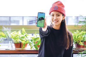 SK텔레콤 홍보모델이 SK텔레콤의 0(영)과 카카오의 라이징스타 죠르디를 활용해 만든 캐릭터 ‘사죠영’을 소개하고 있다. SK텔레콤과 카카오는 양사 IP(지적재산권)를 활용해 대대적인 콜라보 마케팅에 나선다.[SK텔레콤 제공]