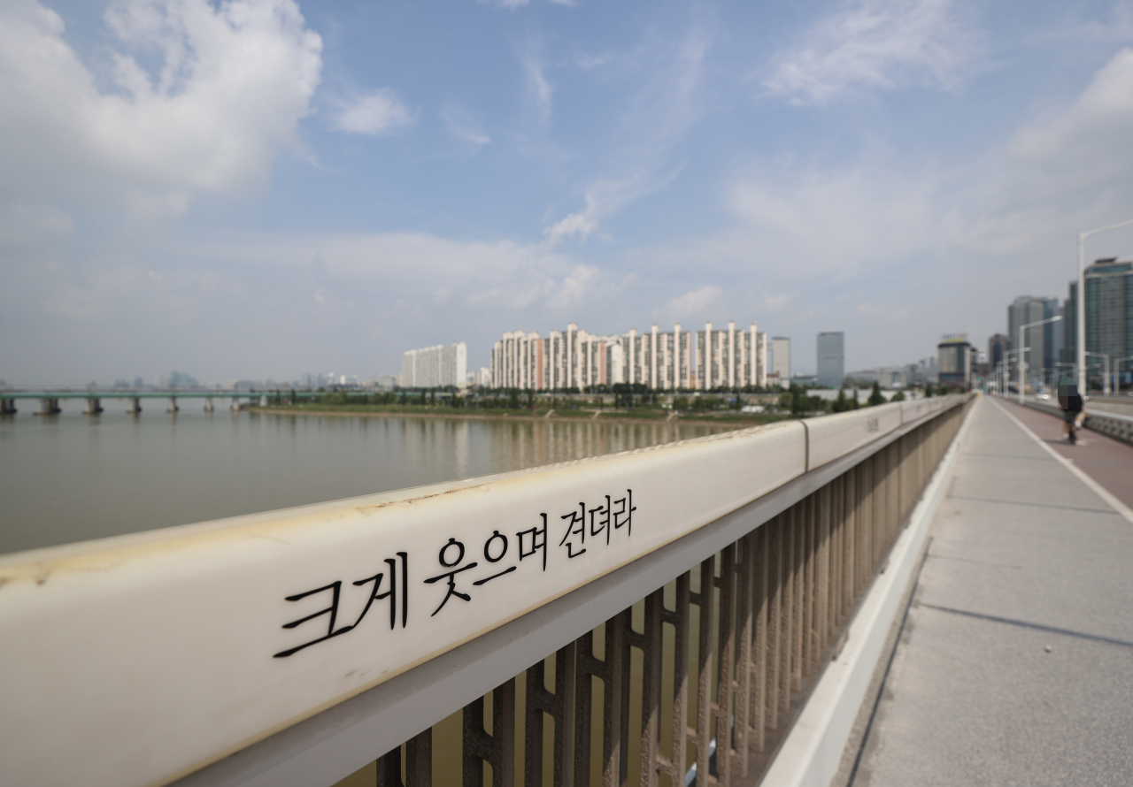 세계 자살예방의 날인 10일 서울 한강 한강대교 보도 난간에 '크게 웃으며 견뎌라'는 문구가 새겨져 있다. [연합]