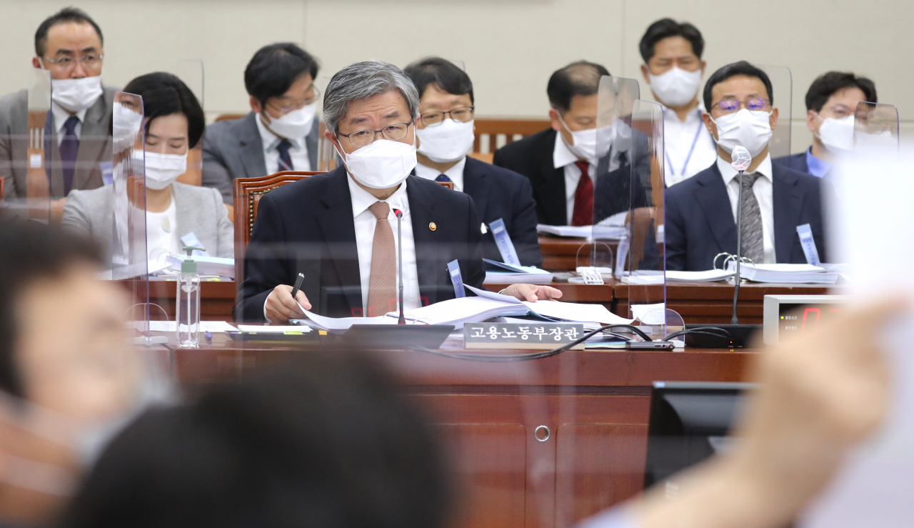 이재갑 고용노동부장관이 국회 환경노동위원회 국정감사가 열린 8일 오전 서울 여의도 국회 환노위 회의실에서 공공부문 비정규직 근로자 정규직 전환과 관련해 국민의힘 김웅 의원이 들어보이는 인천공항 소방대 직원의 근로계약 종료통보서를 보고 있다. [연합]