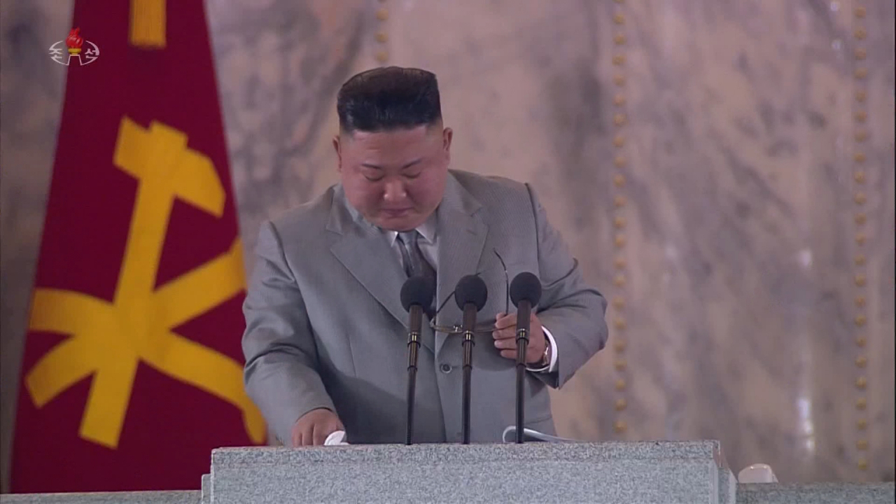 국가안보전략연구원은 11일 김정은 북한 국무위원장이 전날 노동당 창건 75주년 기념 열병식에서 인민에게 미안하고 고맙다는 언급을 되풀이함으로써 인민중시 지도자상을 부각하려 했다고 평가했다. 김 위원장이 연설 도중 재난을 이겨내자고 언급하는 과정에서 울컥한 듯 안경을 벗고 눈물을 훔치고 있다. [평양 조선중앙TV=연합]