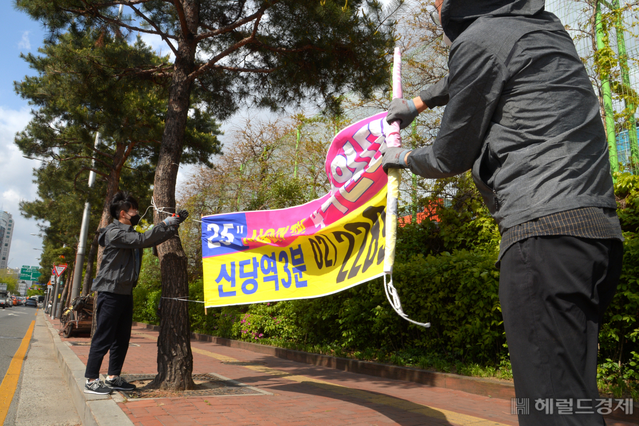 가로수 사이에 걸린 불법 현수막을 철거하고 있다. [중구 제공]