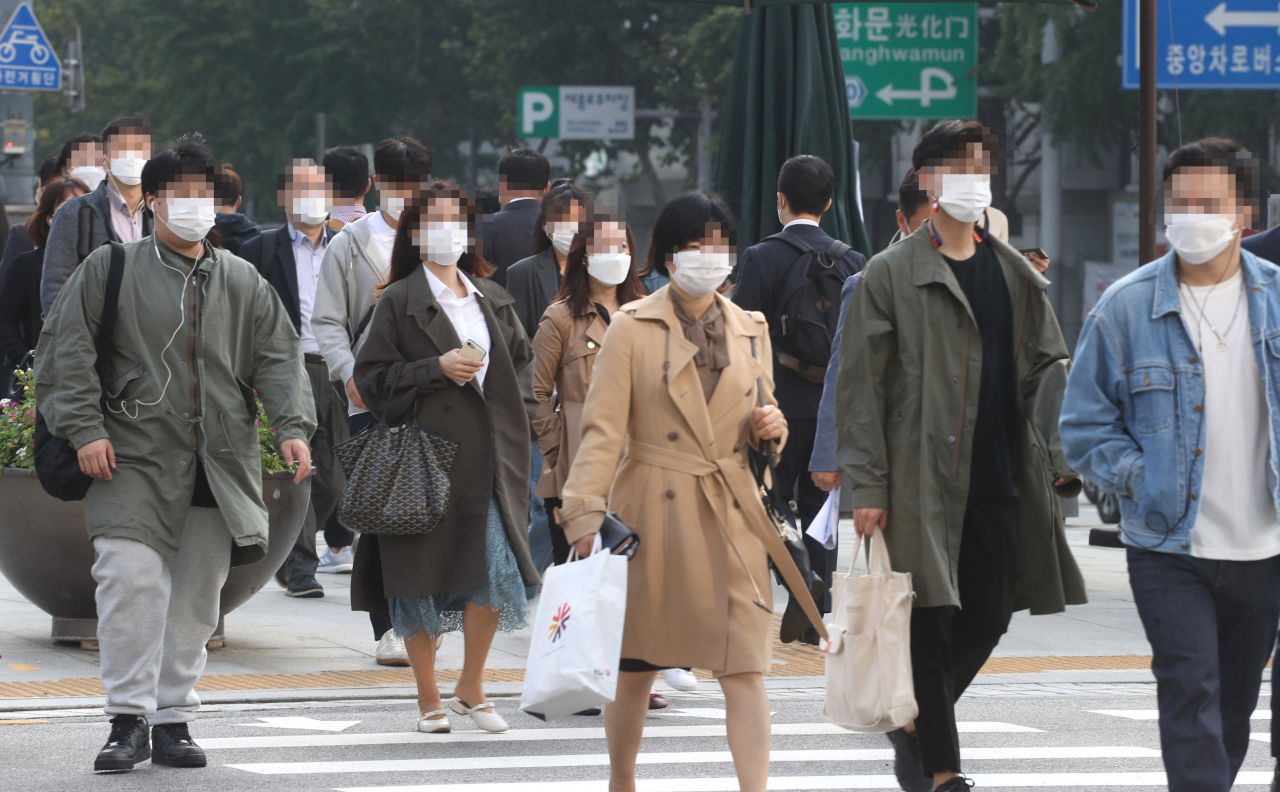 코로나19 사회적 거리 두기를 1단계로 완화한 12일 오전 시민들이 마스크를 쓰고 서울 광화문 사거리를 지나고 있다. [연합]