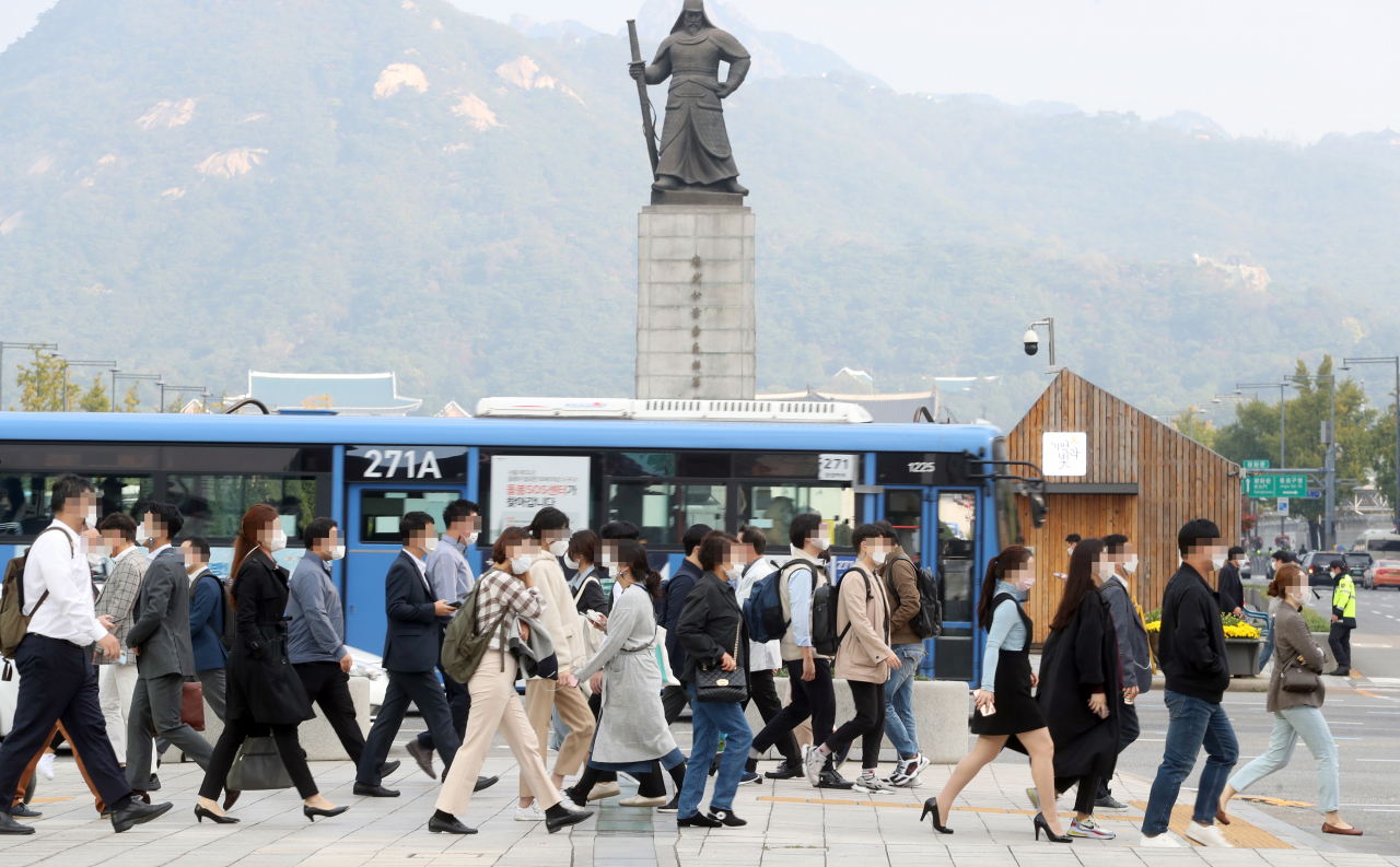 코로나19 사회적 거리 두기를 1단계로 완화한 12일 오전 시민들이 마스크를 쓰고 서울 광화문 사거리를 지나고 있다. [연합]