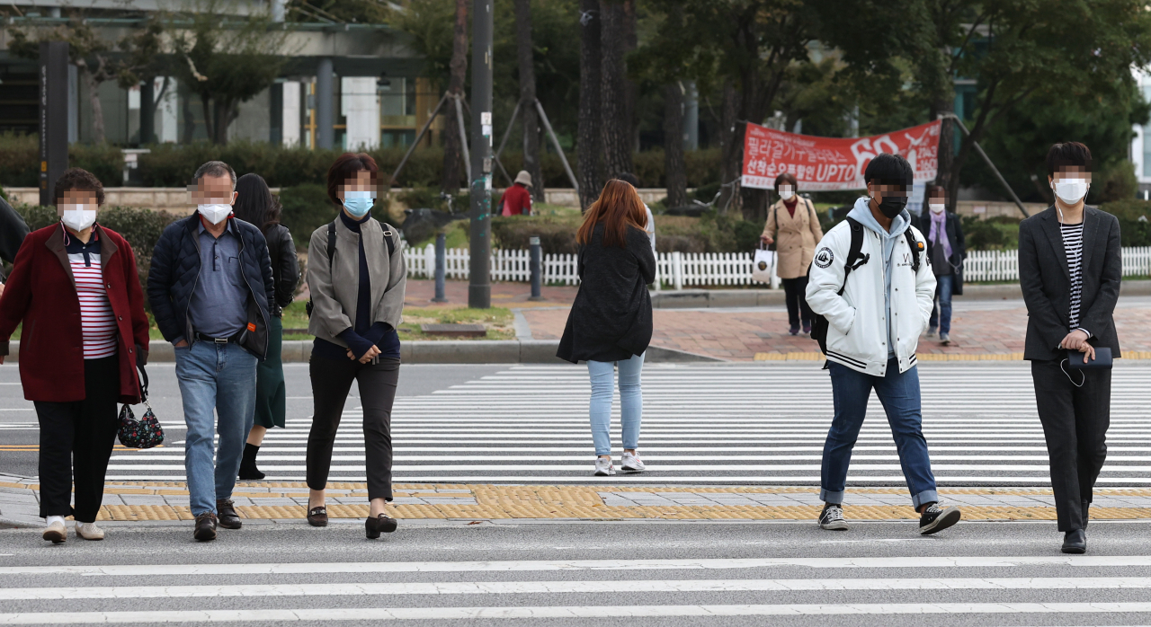 쌀쌀한 날씨를 보이는 13일 오전 서울 송파구 잠실역사거리에서 출근길 시민들이 발걸음을 옮기고 있다. [연합]