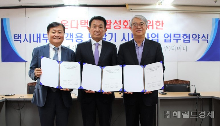 김태극(오른쪽부터) ㈜티머니 대표, 문충석 서울특별시택시운송사업조합 이사장, 류병철 ㈜티오21콤즈 대표가 ‘택시내부 승객용 단말기 시범사업 업무협약’을 체결한 뒤 기념사진을 찍고 있다.