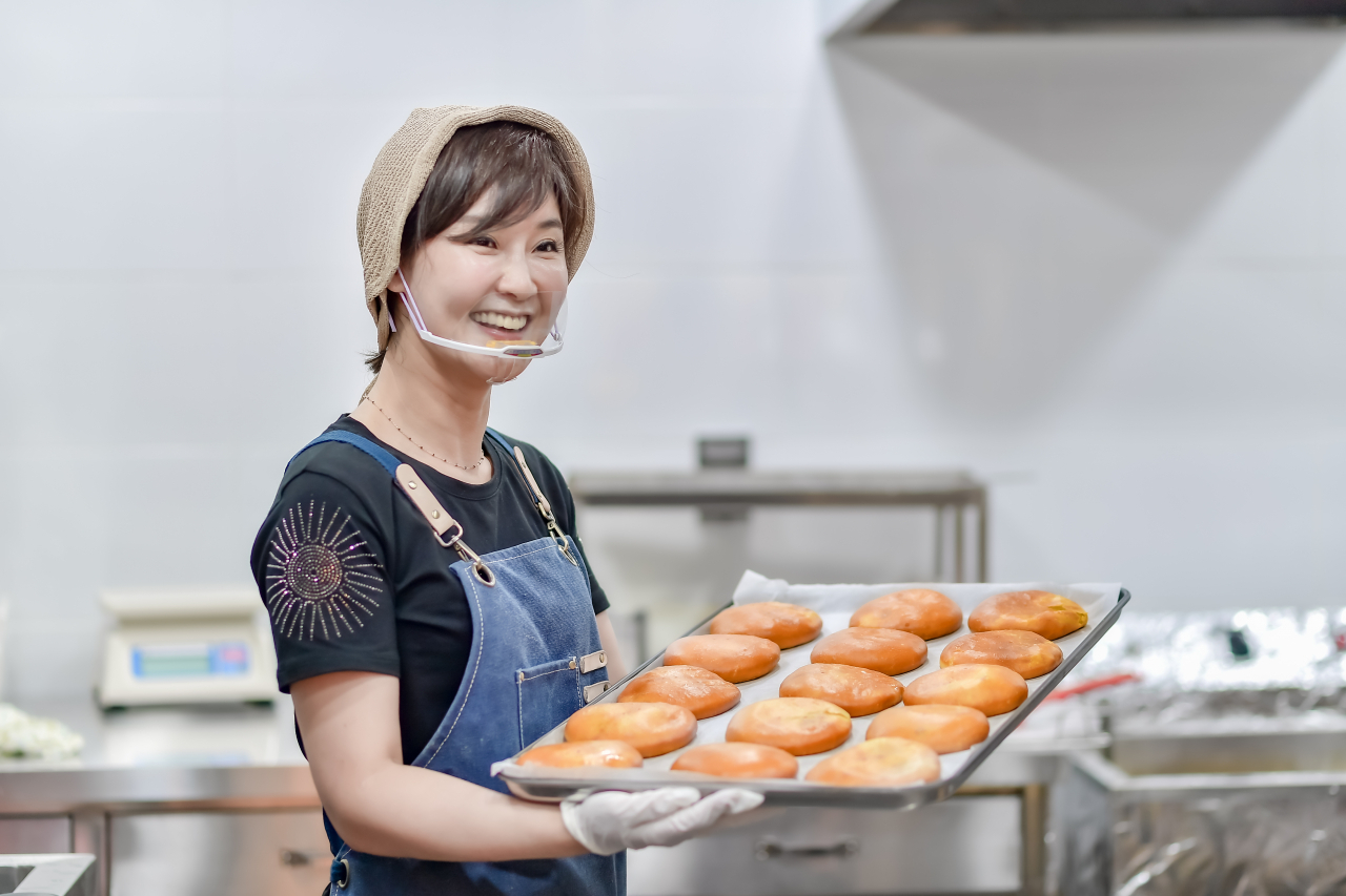 욕지고메원 통영직영점 김나연 대표가 직접 만든 도넛을 들어보이고 있다. [욕지고메원 제공]