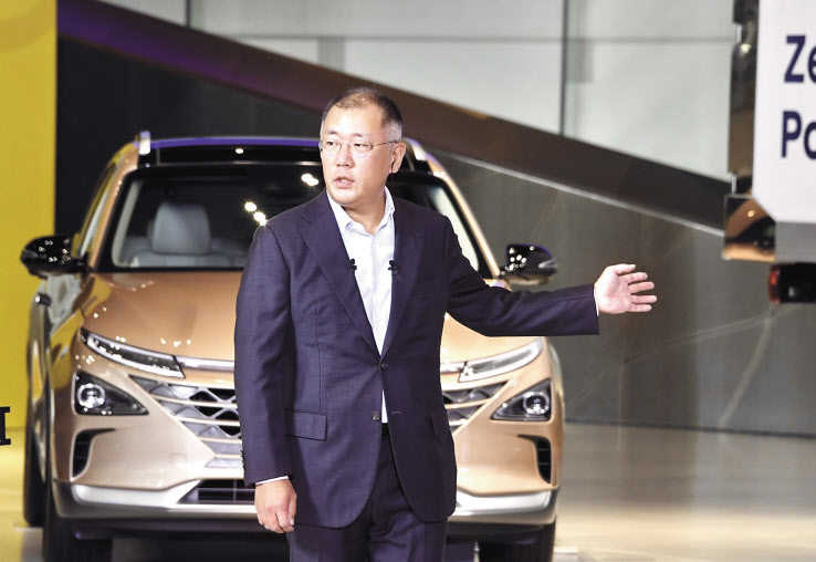 지난 7월 14일 ‘한국판 뉴딜 국민보고대회’에서 그린뉴딜 대표로 화상을 통해 관련 발표자로 나선 정의선 현대차그룹 수석부회장이 현대 모터스튜디오 고양에 전시돼 있는 수소전기차 넥쏘를 소개하고 있다. [현대자동차 제공]