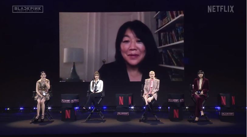 Members of Blackpink hold a global conference about documentary “Blackpink: Light Up the Sky,” joined through videoconference by director Caroline Suh, on Tuesday in Seoul. (Screen capture of livestreamed video on YouTube)