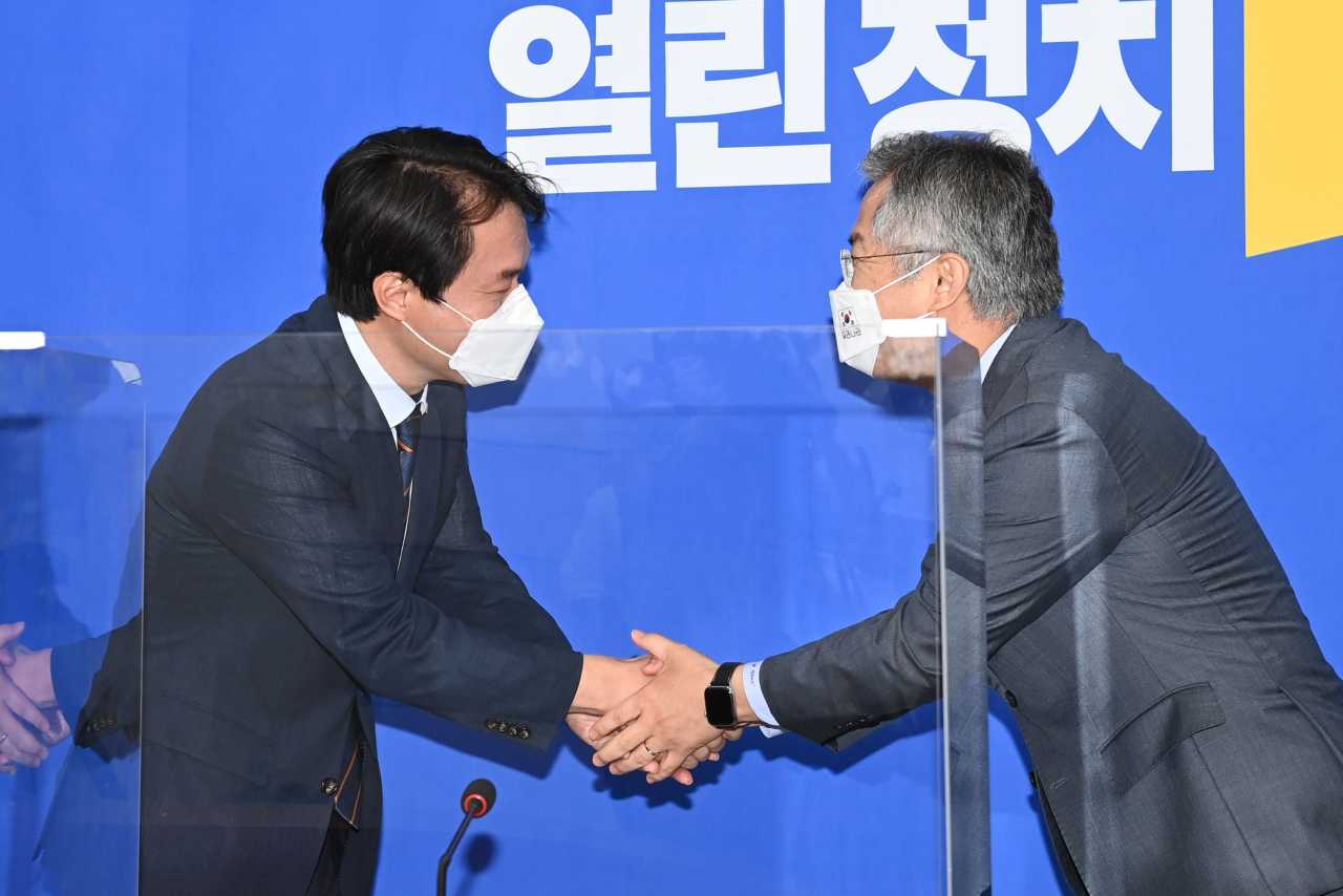 최강욱 열린민주당 대표(오른쪽)가 14일 오전 서울 여의도 국회에서 김종철 정의당 신임 대표를 접견하며 악수를 하고 있다. [연합]