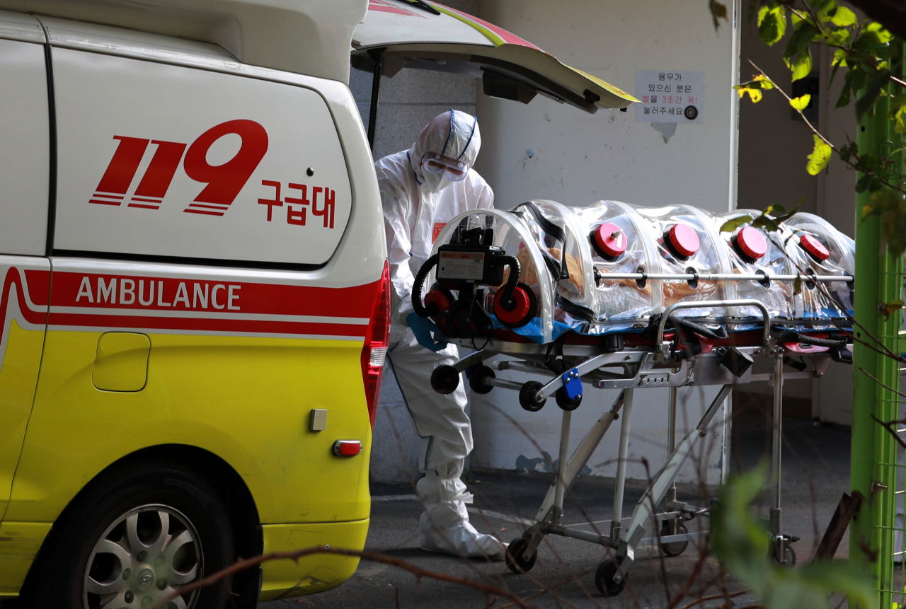 14일 오전 부산 북구 만덕동 해뜨락 요양병원에서 코로나19 환자 이송이 진행되고 있다. 이 요양병원은 직원 9명과 환자 43명이 신종 코로나바이러스 감염증 확진 판정을 받아 동일집단 격리에 들어갔다. [연합]