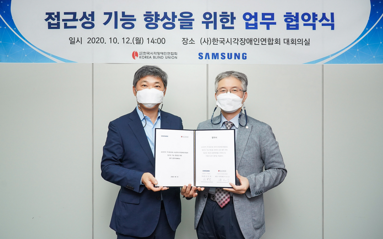 삼성전자 영상디스플레이사업부 천강욱(왼쪽) 부사장과 사단법인 한국시각장애인연합회 박종운 회장 직무대행이 지난 12일 TV 접근성 기능 향상을 위한 업무 협약을 체결한 후 기념촬영을 하고 있는 모습. [삼성전자 제공]