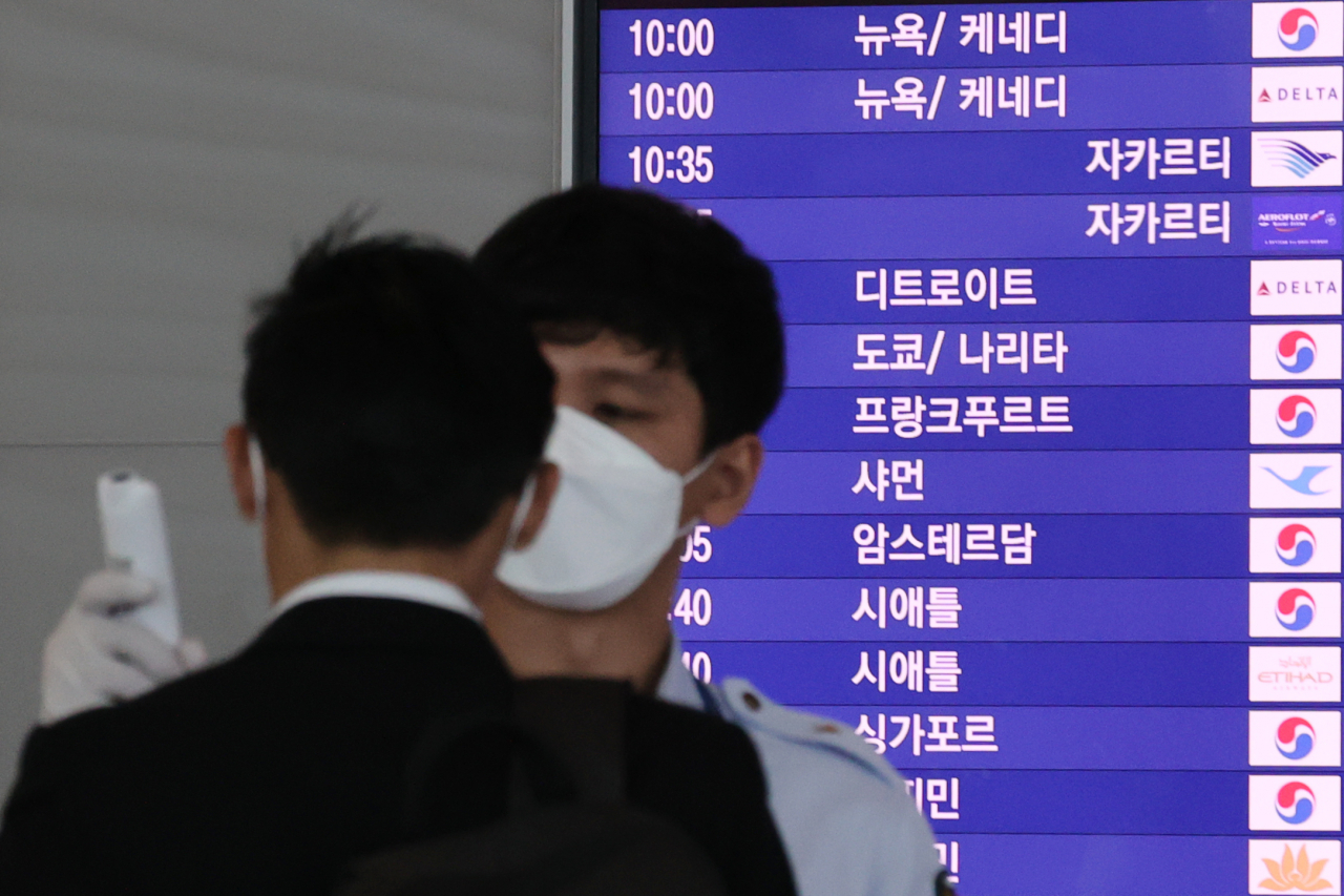 한일간 '기업인 특별입국절차'가 시행된 이달 8일 오전 인천국제공항 제2여객터미널 출국장에서 한 이용객이 출국 전 발열 확인을 하고 있다. [연합뉴스]