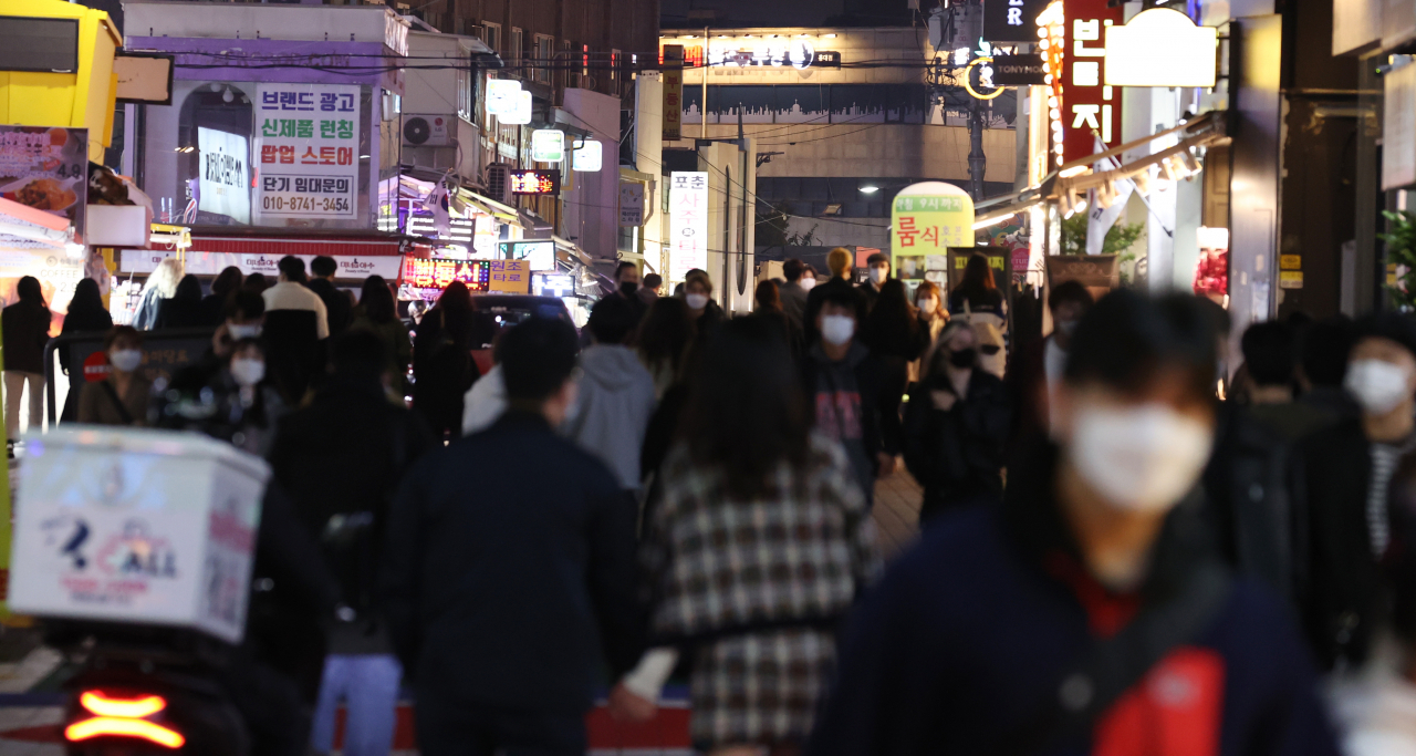 '코로나19' 대응을 위한 사회적 거리 두기가 1단계로 완화되고 첫 주말이 시작된 지난 16일 밤 서울 마포구 홍대축제거리에서 시민들이 오가고 있다.신규 확진자는 전날 110명을 기록하며 세 자릿수로 올라섰지만, 다시 100명 아래로 떨어졌다. [연합]