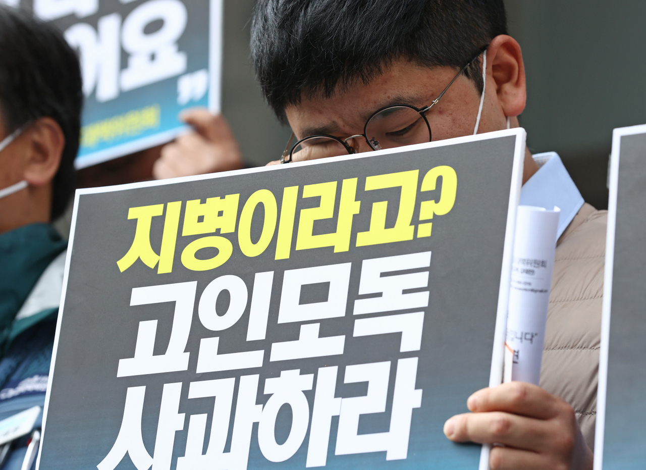 19일 오전 서울 중구 한진택배 본사 앞에서 택배노동자과로사대책위원회 주최로 열린 한진택배 규탄 기자회견에서 사망한 택배노동자 고 김 모씨의 동생이 손팻말을 들고 있다. [연합]
