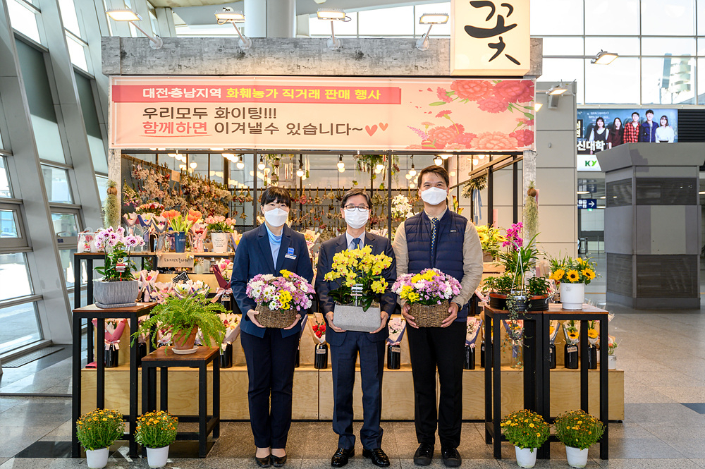 손병석 한국철도 사장(가운데)이 지난 19일 오후 신종 코로나바이러스 감염증(코로나19)으로 어려움을 겪고 있는 화훼농가를 돕기 위한 ‘플라워 버킷 챌린지’의 일환으로 대전역 내 화훼판매장에서 꽃을 구입해 감염증 확산 방지를 위해 노력하고 있는 직원들에게 전했다. [한국철도(코레일) 제공]