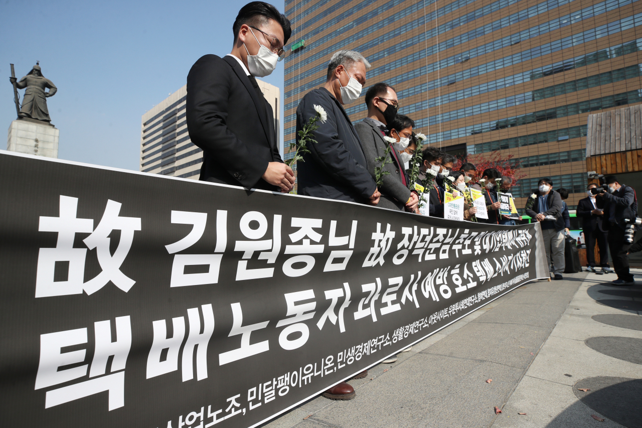 지난 19일 오후 서울 종로구 광화문광장에서 열린 ‘대기업 택배사 규탄과 택배기사 과로사 예방 호소하는 택배 소비자 기자회견’에서 참석자들이 묵념을 하고 있다. [연합]