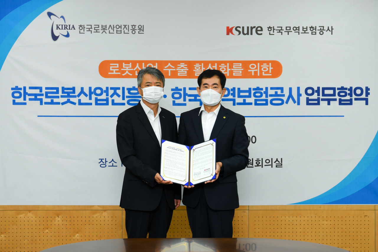이인호(왼쪽) 한국무역보험공사 사장이 20일 대구 북구 로봇산업진흥원에서 진행된 '로봇산업 수출 활성화를 위한 업무협약식'에서 기념촬영을 하고 있다. [한국무역보험공사 제공]