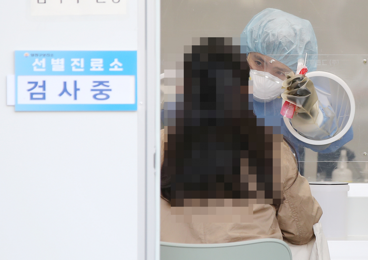 지난 20일 오후 서울 양천구보건소에 마련된 선별진료소를 찾은 시민이 검체 검사를 받고 있다. [연합]