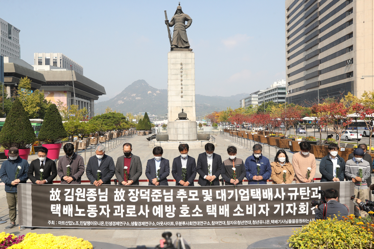 지난 19일 오후 서울 광화문광장 앞에서 열린 ‘대기업 택배사 규탄과 택배노동자 과로사 예방 호소하는 택배 소비자 기자회견’에서 참석자들이 최근 숨진 택배기사들을 추모하는 묵념을 하고 있다. [연합]