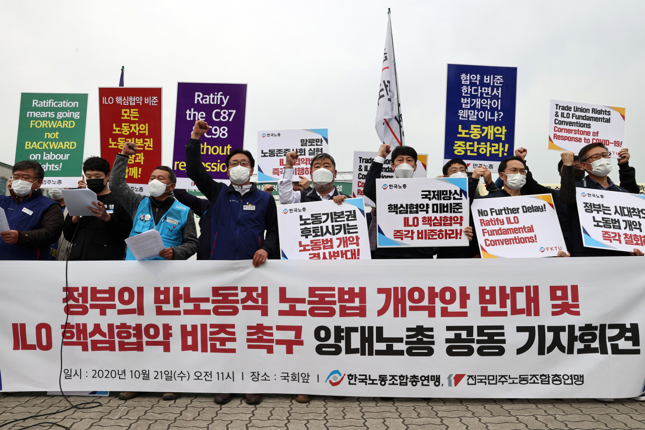 21일 오전 서울 국회 앞에서 열린 '정부의 반노동적 노동법 개악반대 및 ILO핵심협약 비준촉구 양대노총 기자회견'에서 한국노총 김동명 위원장(앞줄 오른쪽 4번째)과 민주노총 김재하 비상대책위원장(앞줄 왼쪽 4번째)을 비롯한 참가자들이 관련 구호를 외치고 있다. [연합]