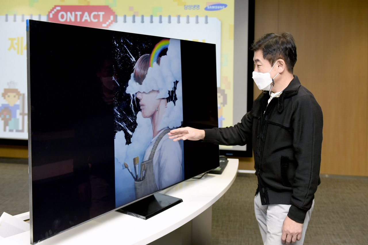 삼성전자의 QLED TV가 미술대회의 작품 심사에 활용돼 눈길을 끌고 있다. 삼성생명 미술대회 후원 미술대학의 한 심사위원이 지난 21일 서울 서초동에 위치한 삼성생명 컨퍼런스룸에서 삼성 QLED 8K TV를 활용해 삼성생명이 주최하는 '제 40회 청소년 미술대회' 예선 작품을 심사하고 있다. [삼성전자 제공]