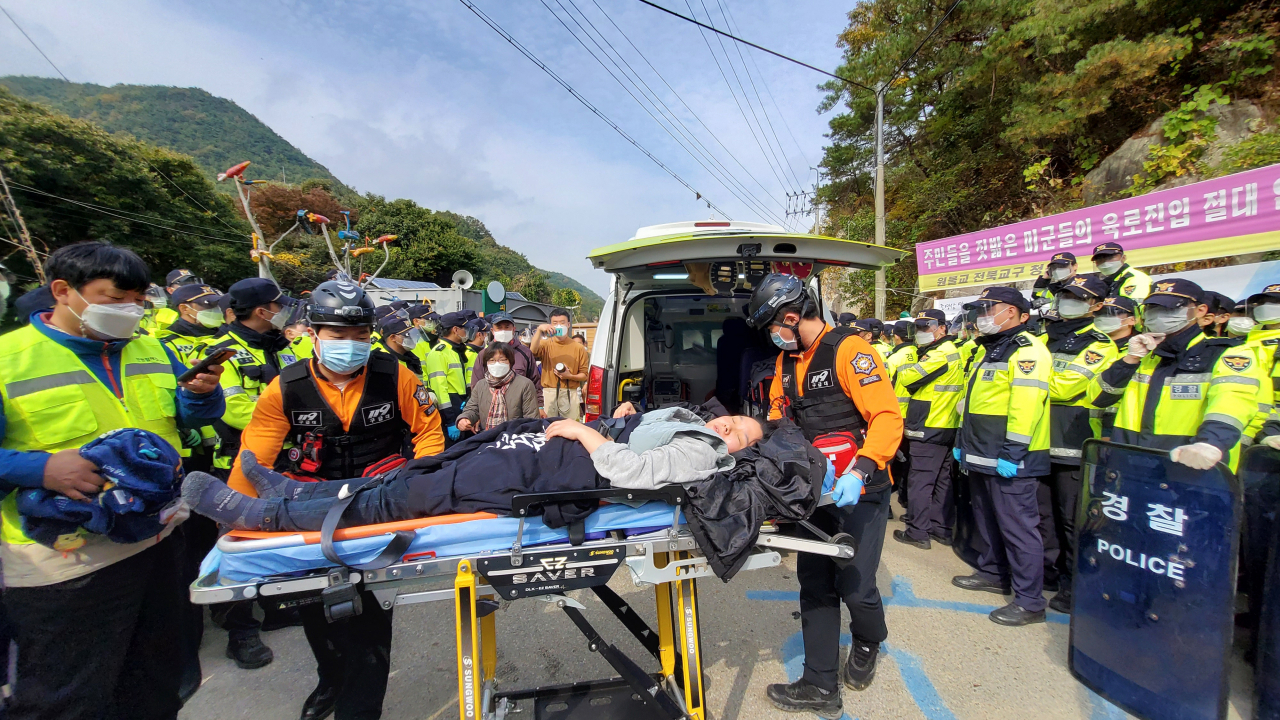 국방부가 경북 성주 초전면 소성리 사드(THAAD·고고도미사일방어체계) 기지에 공사 장비를 반입한 22일 진밭교에서 시위하던 주민이 부상으로 119구급대 들것에 실려 가고 있다.[연합]