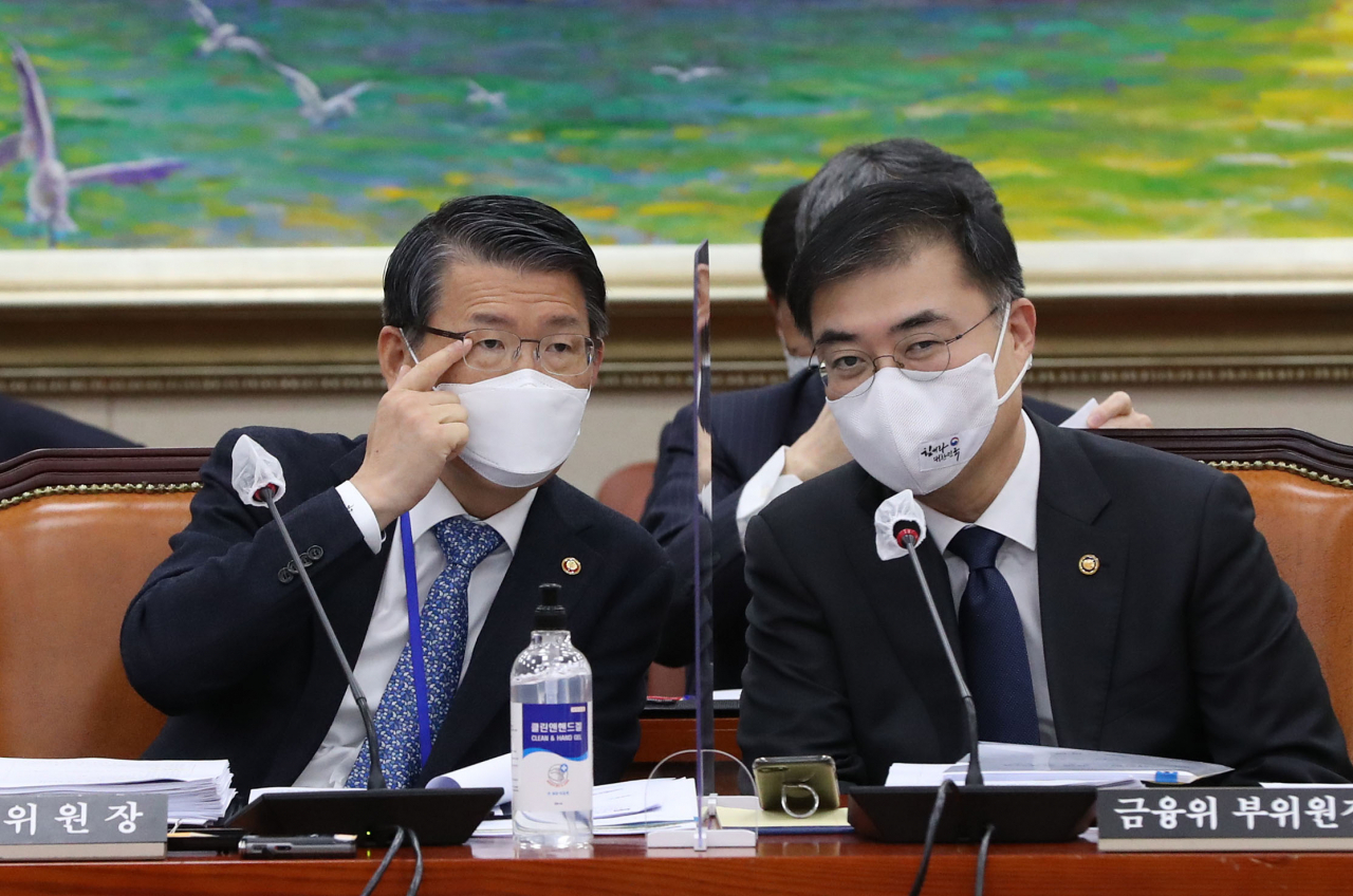 은성수 금융위원장(왼쪽)과 손병두 부위원장이 23일 국회 정무위원회 국정감사에서 대화하고 있다. [연합]