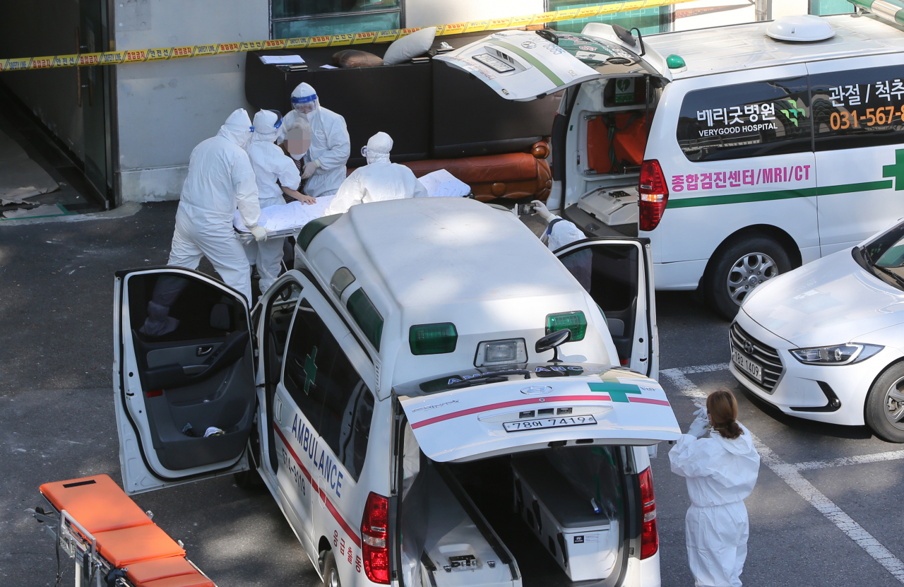 23일 경기도 남양주 오남읍의 한 요양원에서 보건소 관계자들이 입소자를 이송하고 있다. 이 곳 요양원에서는 입소자와 종사자들이 무더기로 확진되는 집단감염이 발생, 건물 전체를 코호트 격리 조치했다. [연합]