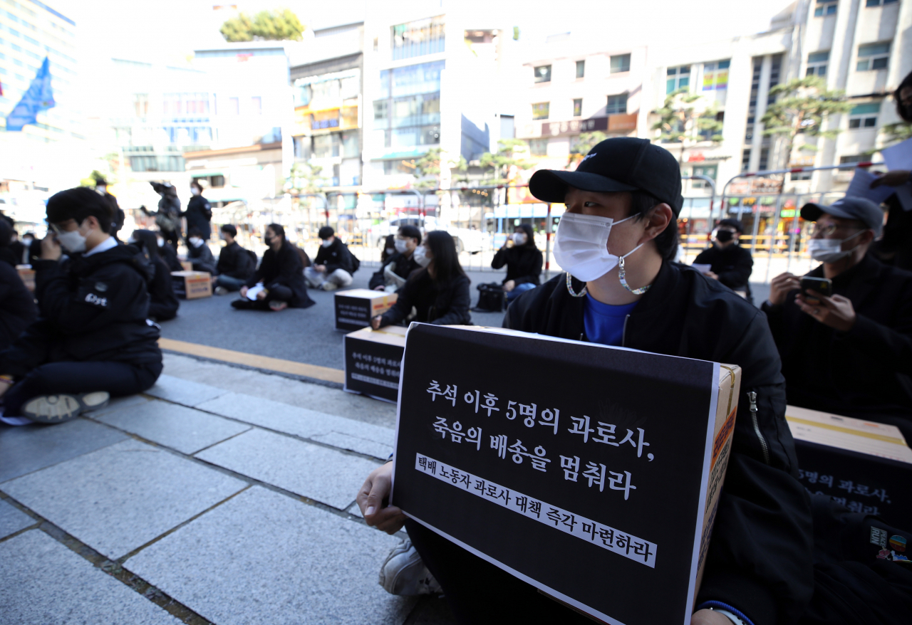 지난 24일 오후 서울 중구 한진택배 본사 앞에서 청년하다 등 단체 관계자들이 택배 노동자 과로사 대책 마련을 촉구하는 집회를 열고 있다. [연합]