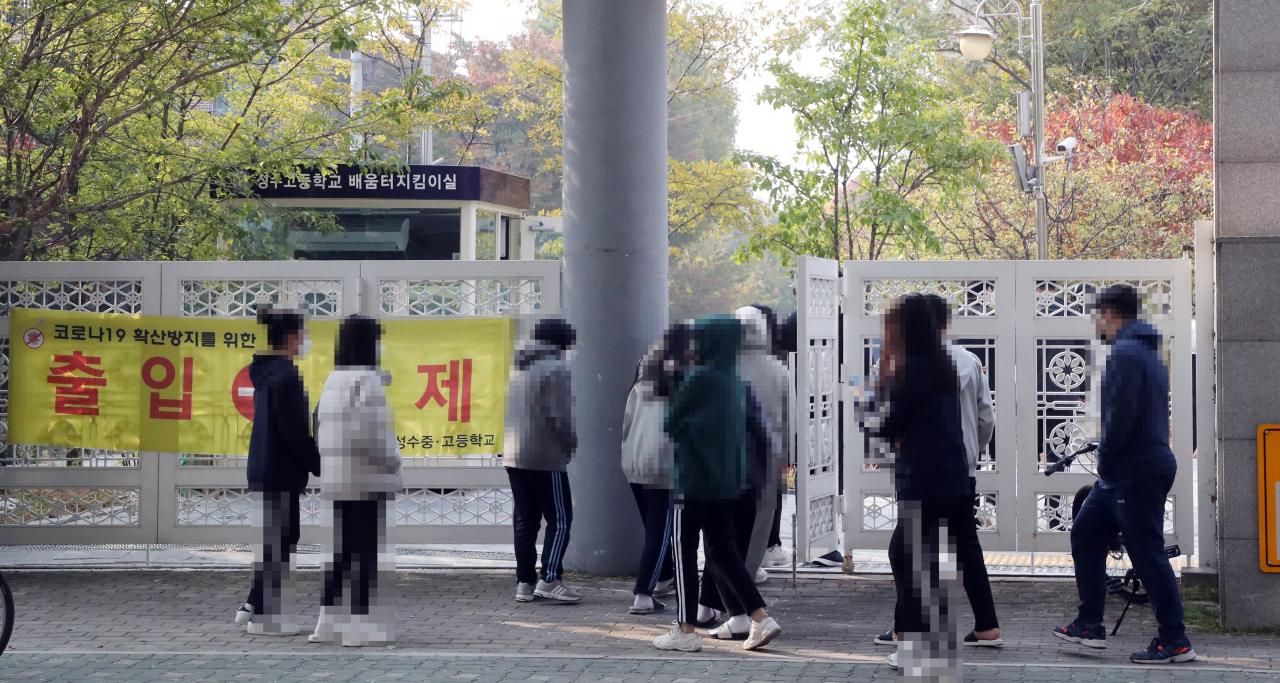 3학년 학생 한명이 코로나19 확진 판정을 받은 서울 성동구 성수고등학교에 학생들 전수검사를 위해 27일 임시 선별진료소가 차려졌다. 학생들이 검사를 받기위해 학교로 들어가고 있다. 연합뉴스