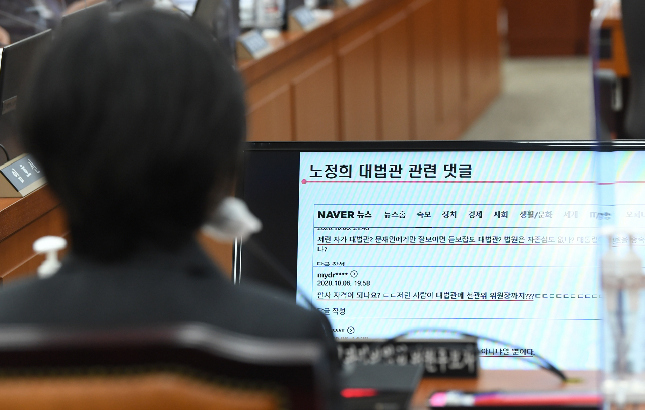 노정희 중앙선거관리위원 후보자가 27일 서울 여의도 국회에서 열린 인사청문회에 출석해 김용판 국민의힘 의원이 질의 도중 공개한 노 후보자 관련 포털 댓글 화면을 보고 있다. [연합]