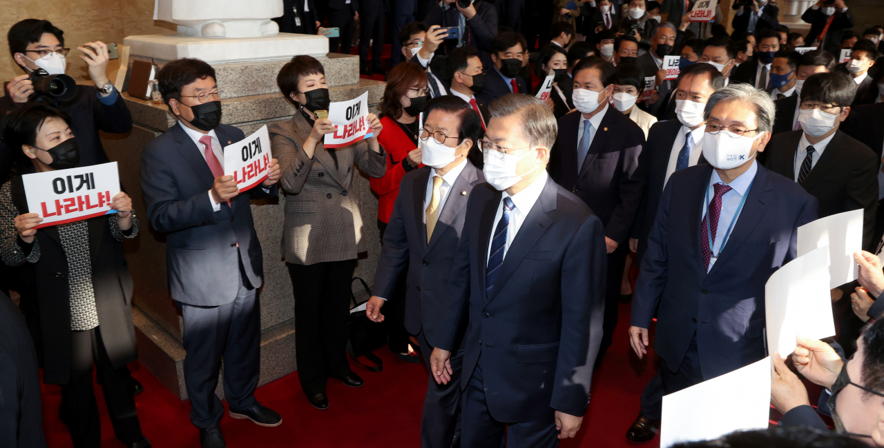 문재인 대통령이 28일 오전 2021년도 예산안 시정연설을 하기 위해 국회 본회의장으로 들어서고 있다. 문 대통령이 입장하자 국민의 힘 의원들이 라임·옵티머스 특검을 요구하는 손팻말을 들고 있다. [연합]