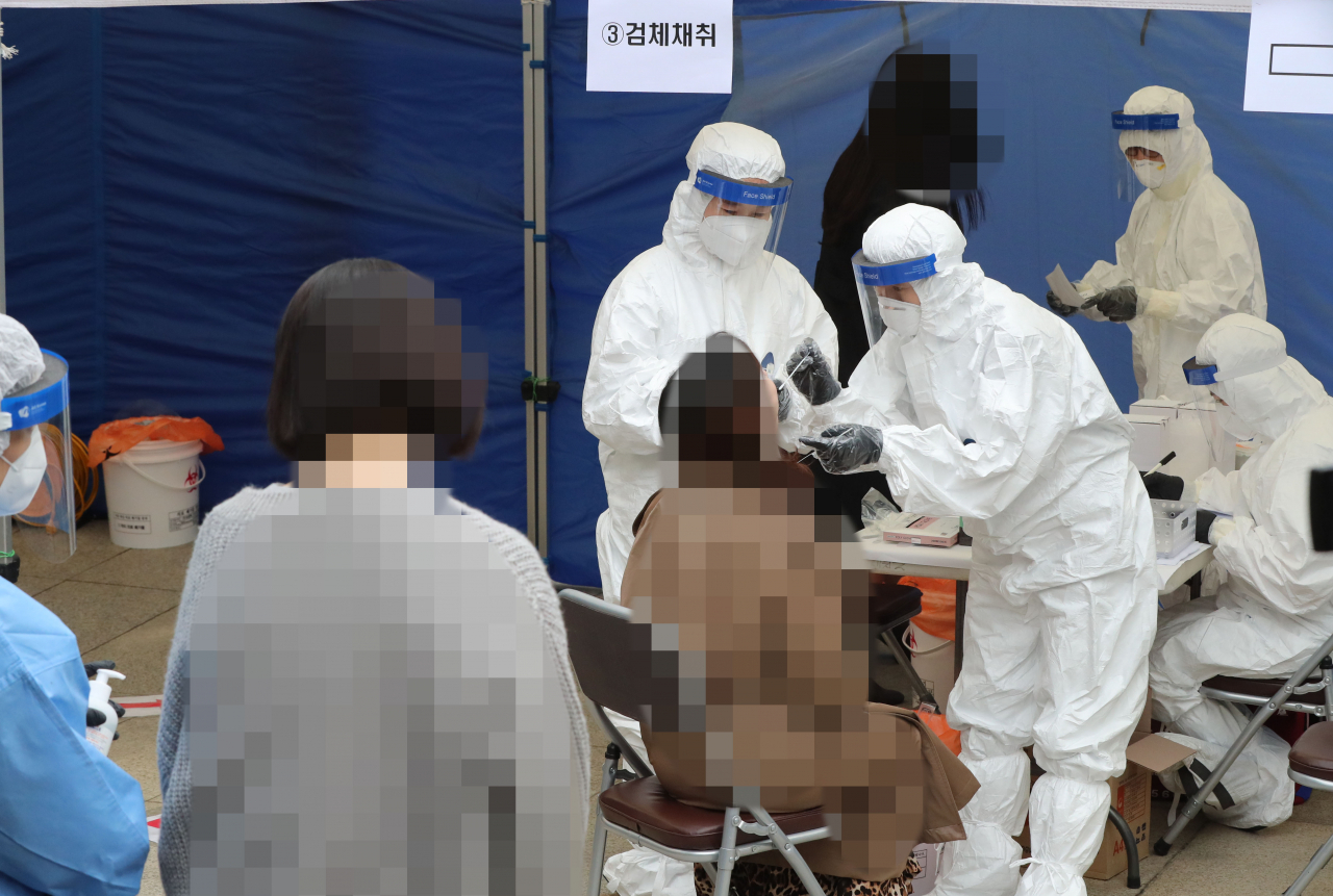 지난 21일 오후 서울 강남구 대치2동주민센터 앞에 설치된 선별진료소에서 관내 학원강사들이 신종 코로나바이러스 감염증(코로나19) 진단검사를 받고 있다. [연합]