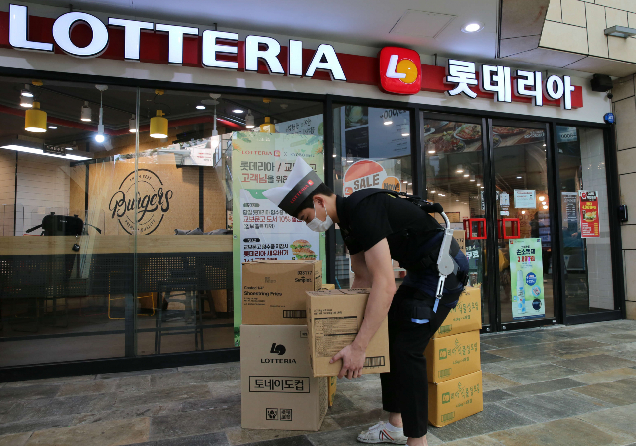 롯데리아 직원이 웨어러블 로봇을 착용한 모습 [제공=롯데GRS]