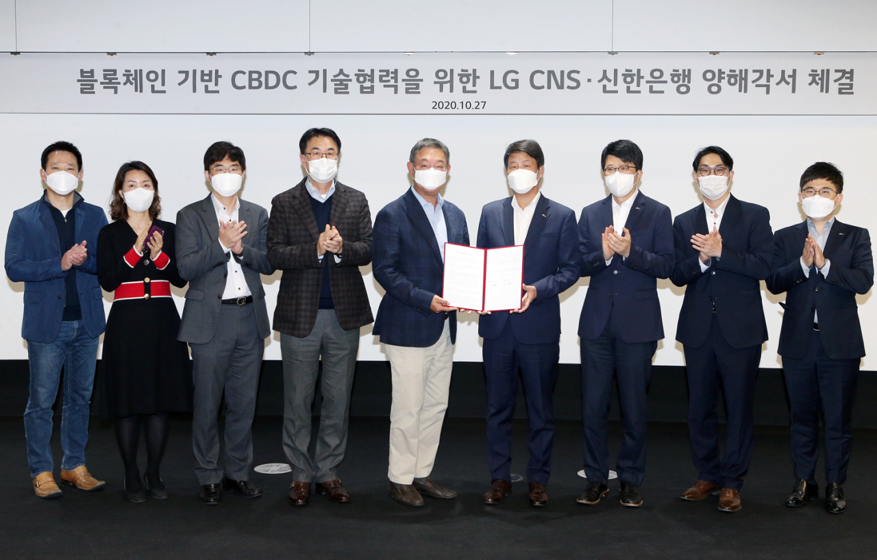 지난 27일 서울시 강서구 마곡중앙로에 위치한 LG CNS 본사에서 진행된 ‘신한은행&bull;LG CNS 블록체인 기반 CBDC 기술협력을 양해각서 체결식’ 에서 신한은행 디지털그룹 이명구 부행장(왼쪽 여섯 번째)과 LG CNS 현신균 부사장(왼쪽 다섯 번째) 및 관계자들이 기념촬영하는 모습. 사진=신한은행