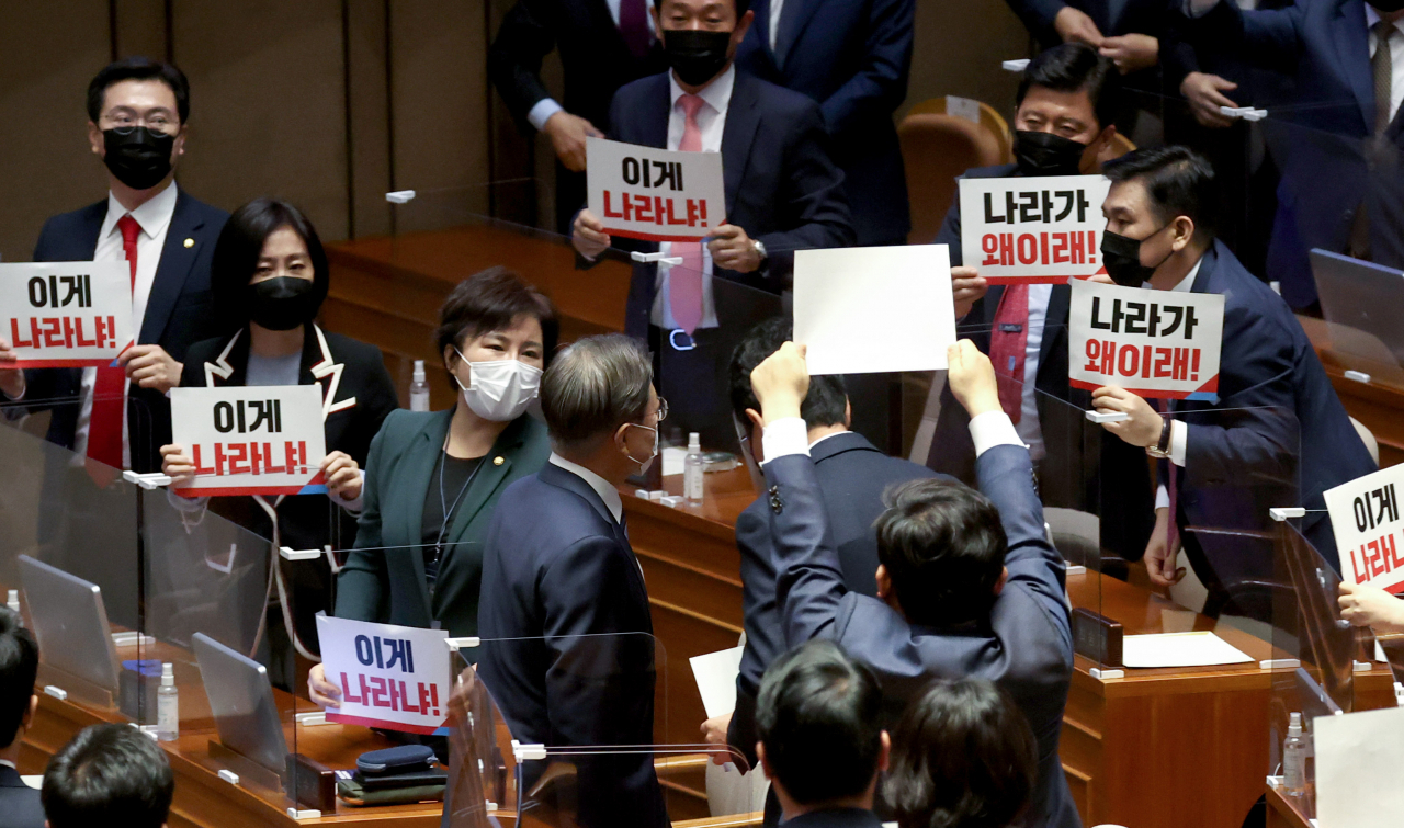 문재인 대통령이 28일 오전 국회 본회의장에서 2021년도 예산안 시정연설을 마친 후 퇴장하자 국민의힘 의원들이 손팻말을 든 채 항의하고 있다. [연합]