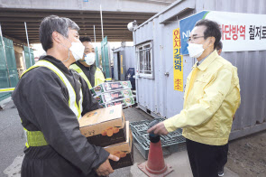 이성희(오른쪽) 농협중앙회장이 천안·아산 AI 현장 공동방제단에 방역물품을 전달하며 차단방역 수칙을 철저히 준수해 줄 것을 당부하고 있다. [농협 제공]