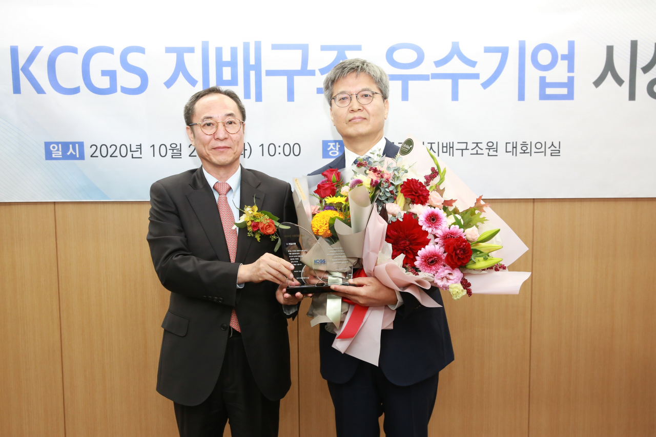 지난 27일 ‘2020년 KCGS 우수기업 시상식’에서 김경환 SC제일은행 운영본부 부행장(오른쪽)이 신진영 KCGS 원장으로부터 지배구조 우수기업 대상(大賞)을 받으며 기념촬영을 하고 있다.