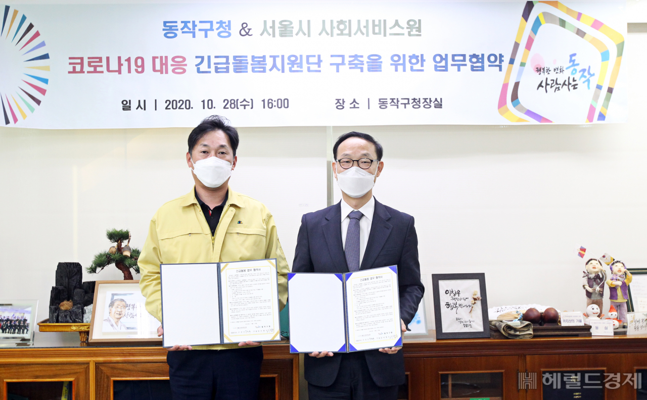 이창우 구청장과 주진우 서울사회서비스원 대표가 28일 업무협약을 한 뒤 협약서를 들어보이고 있다. [동작구 제공]