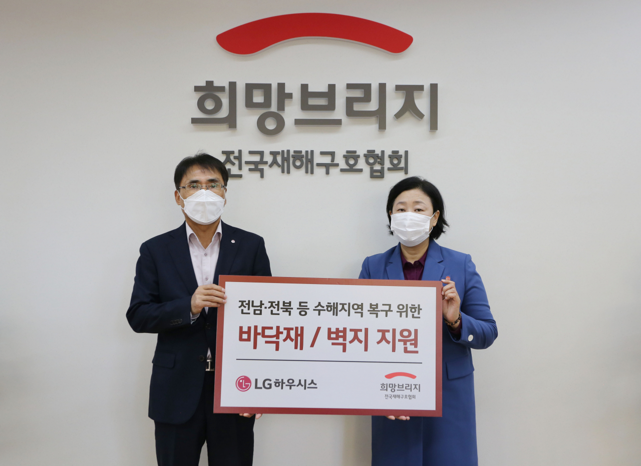 29일 서울 마포구 희망브리지 전국재해구호협회에서 LG하우시스 장식재사업부장 박귀봉 전무(사진 왼쪽)와 희망브리지 전국재해구호협회 김정희 사무총장이 수해복구 자재 전달식 후 기념촬영을 하고 있다. [LG하우시스 제공]