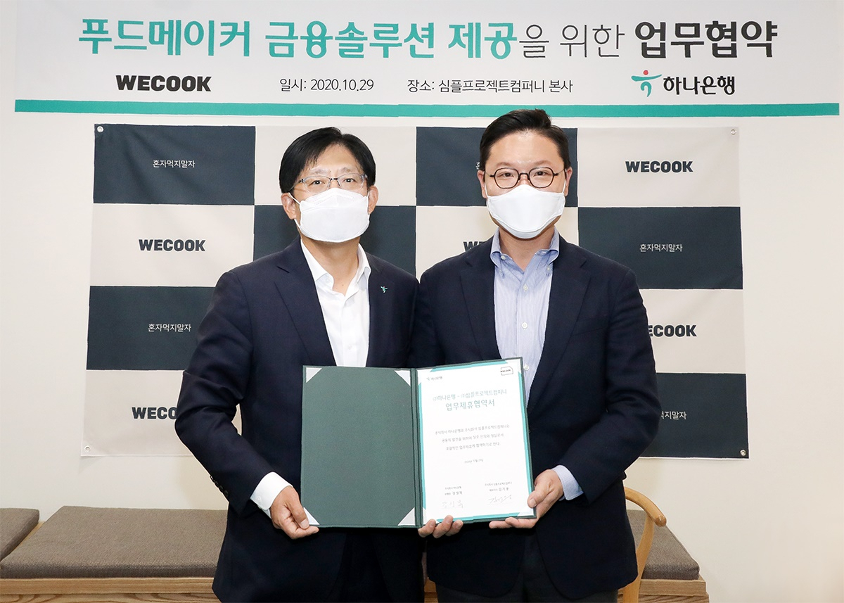 29일 오후 서울 종로구 심플프로젝트컴퍼니 본사에서 김성묵 하나은행 부행장(왼쪽)과 김기웅 (주)심플프로젝트컴퍼니 대표이사가 업무협약을 체결하고 기념촬영을 하고 있다. [하나은행 제공]