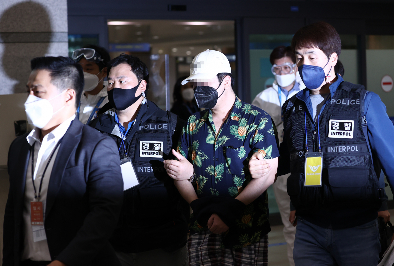 베트남에서 붙잡힌 디지털 교도소 1기 운영자 A씨가 지난 6일 오전 인천국제공항을 통해 강제 송환되고 있다. A씨는 올해 3월부터 디지털 교도소 사이트와 인스타그램 계정 등을 개설·운영하며 디지털 성범죄, 살인, 아동학대 등 사건 피의자의 신상정보와 법원 선고 결과 등을 무단 게시한 혐의를 받는다. [연합]