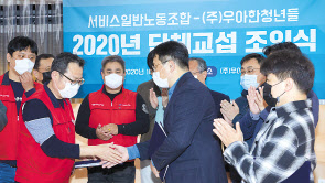 22일 서울 송파구에서 진행된 우아한청년들과 민노총 서비스일반노동조합의 단체교섭 조인식에서 우아한청년들 김병우 대표(오른쪽)와 민주노총 서비스일반노조 이선규 위원장이 국내 첫 플랫폼 기업과 종사자 간 단체협약에 서명한 뒤 악수를 하고 있다.