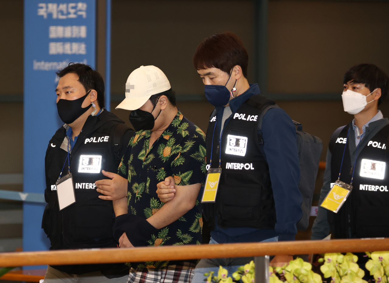 베트남에서 붙잡힌 디지털 교도소 1기 운영자 A씨가 지난달 6일 오전 인천국제공항을 통해 강제 송환되고 있다. A씨는 올해 3월부터 디지털 교도소 사이트와 인스타그램 계정 등을 개설·운영하며 디지털 성범죄, 살인, 아동학대 등 사건 피의자의 신상정보와 법원 선고 결과 등을 무단 게시한 혐의를 받는다. [연합]