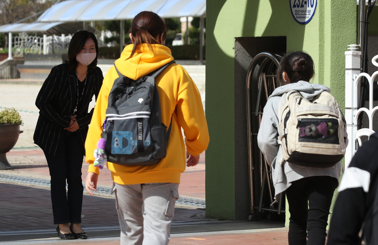 A teacher at a school in Gwangju welcomes back students on Oct. 19, when in-person classes started again. (Yonhap)