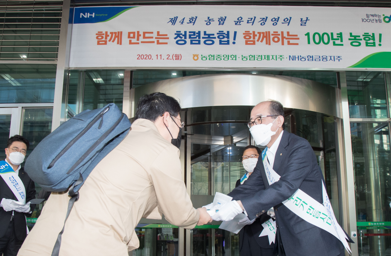 2일 제4회 윤리경영의 날을 맞아 서울시 중구 농협중앙회 본관에서 유찬형 부회장(오른쪽)이 출근하는 임직원들을 대상으로 홍보물을 나누어 주며 윤리경영 실천을 당부하고 있다. [농협 제공]