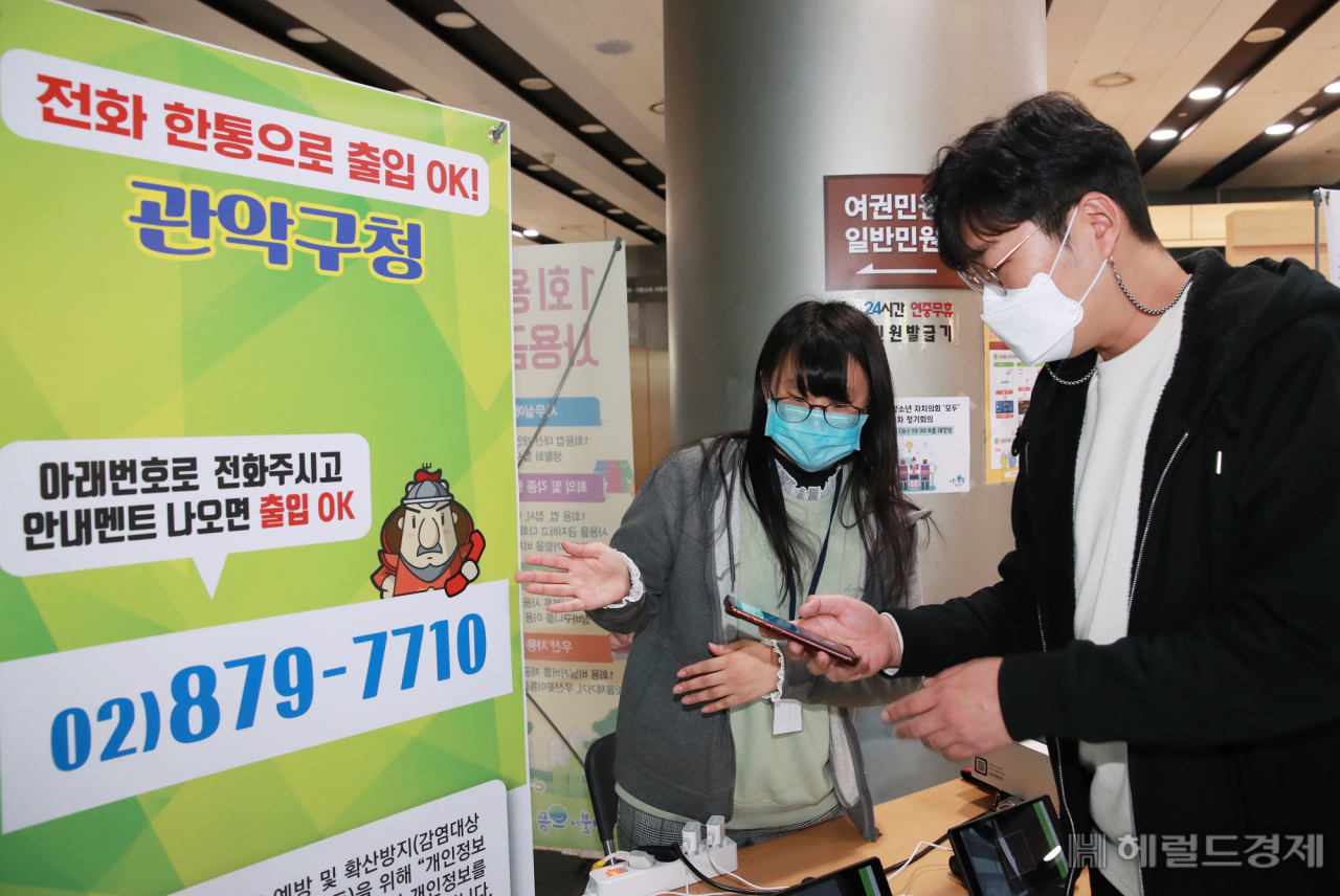 3일 오전 서울 관악구청 지하 1층에서 구민이 구청을 들어가기 위해 출입관리시스템을 통해 구청을 들어가려고 하고 있다. 관악구는 코로나19 예방과 민원인의 방문편의를 위한 출입관리시스템에 전화이력을 이용한 자동연계 관리 방식을 도입, 시행했다. 자동연계 시스템은 구 자체 행정전화 전화이력관리시스템을 활용하여 출입자가 입구에 안내된 전화번호로 통화 후 출입하면 통화 시 남긴 전화이력을 통해 방문시간, 방문자 전화번호를 관리하는 방식이다. 방문자에게 별도의 통화료가 발생하지 않으며, 기록은 4주후 자동으로 폐기된다. [관악구 제공]